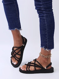 a woman wearing black sandals and jeans